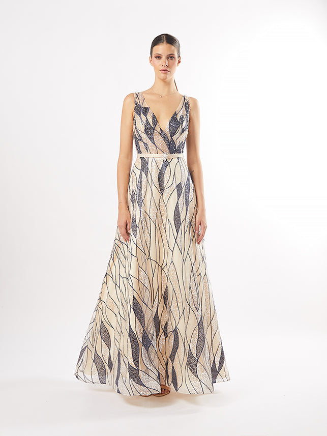 A model in a gold and silver art deco-inspired gown with a deep V-neckline, posing against a clean white background.