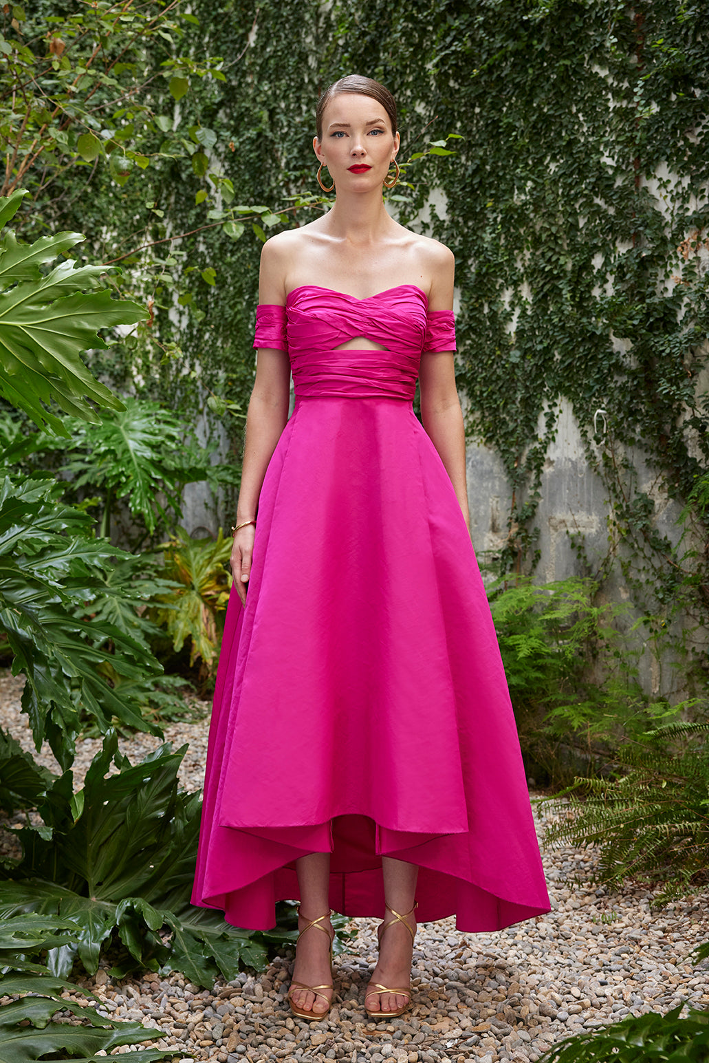 Front view of the model in the fuchsia gown that also comes in red, highlighting the ruched top and sweeping high-low hemline.