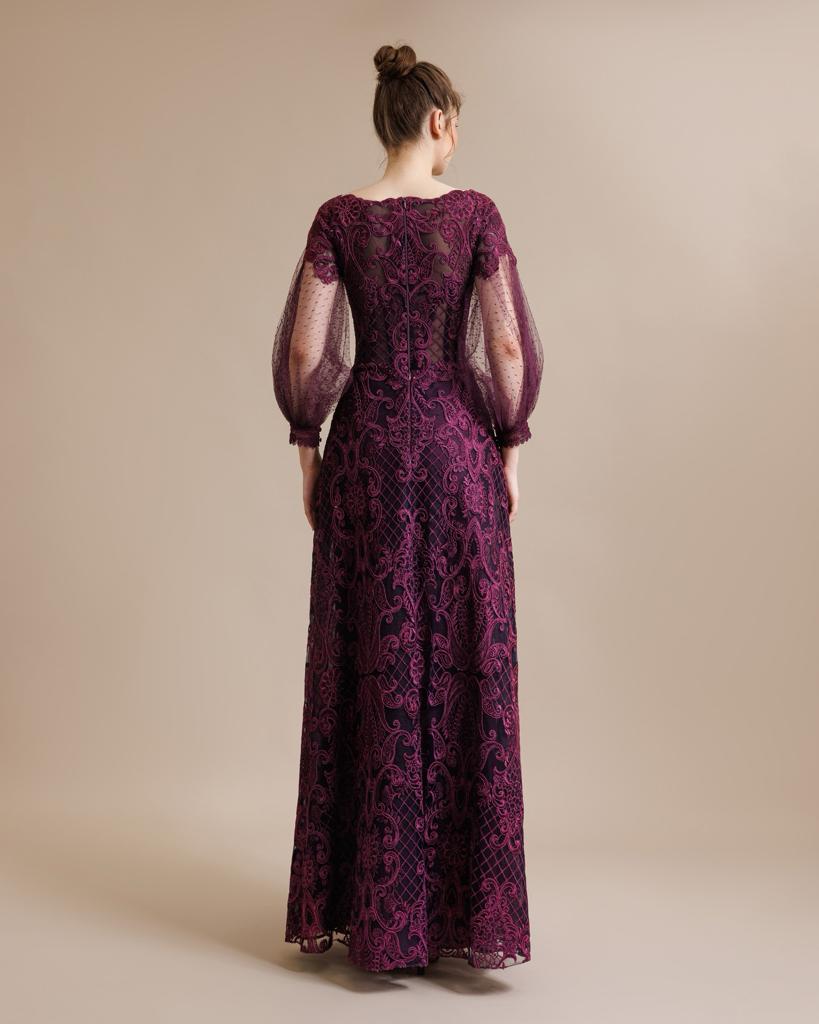 Back view of an aubergine floral lace gown with a sheer lace back and balloon sleeves, emphasizing the intricate lace detailing and elegant train.