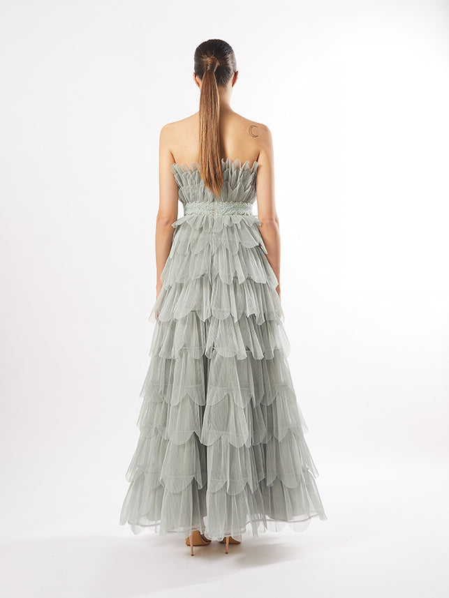 Rear view of the tiered tulle gown with a fitted embellished waistband, in a color that is available in mauve.