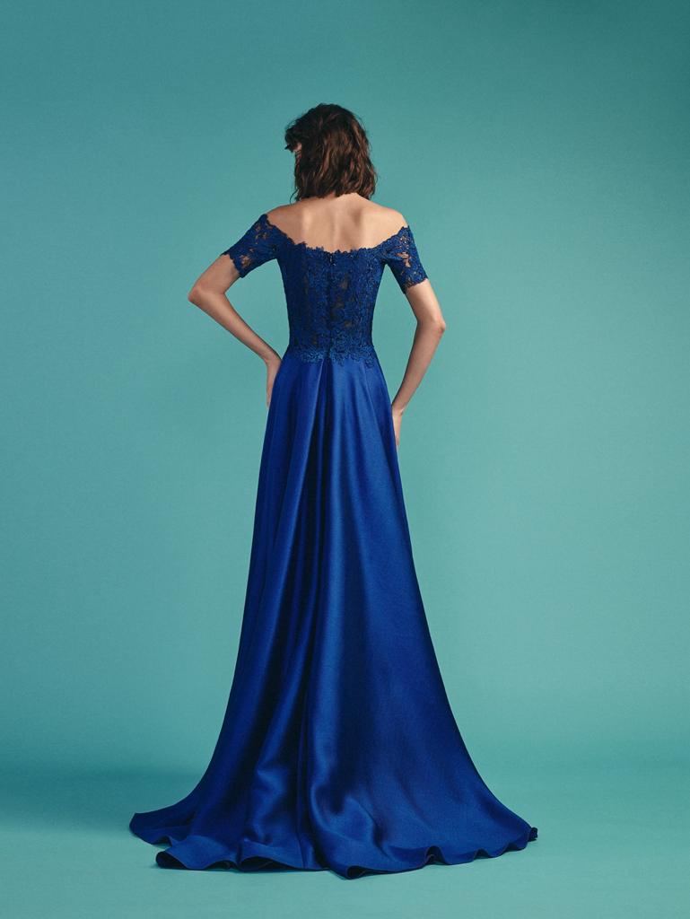 Rear view of a royal sapphire blue gown showcasing a lace-embellished bodice and a flowing satin skirt with a train, set against a teal background.